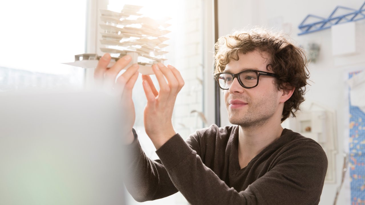 Man in office on phone with laptop